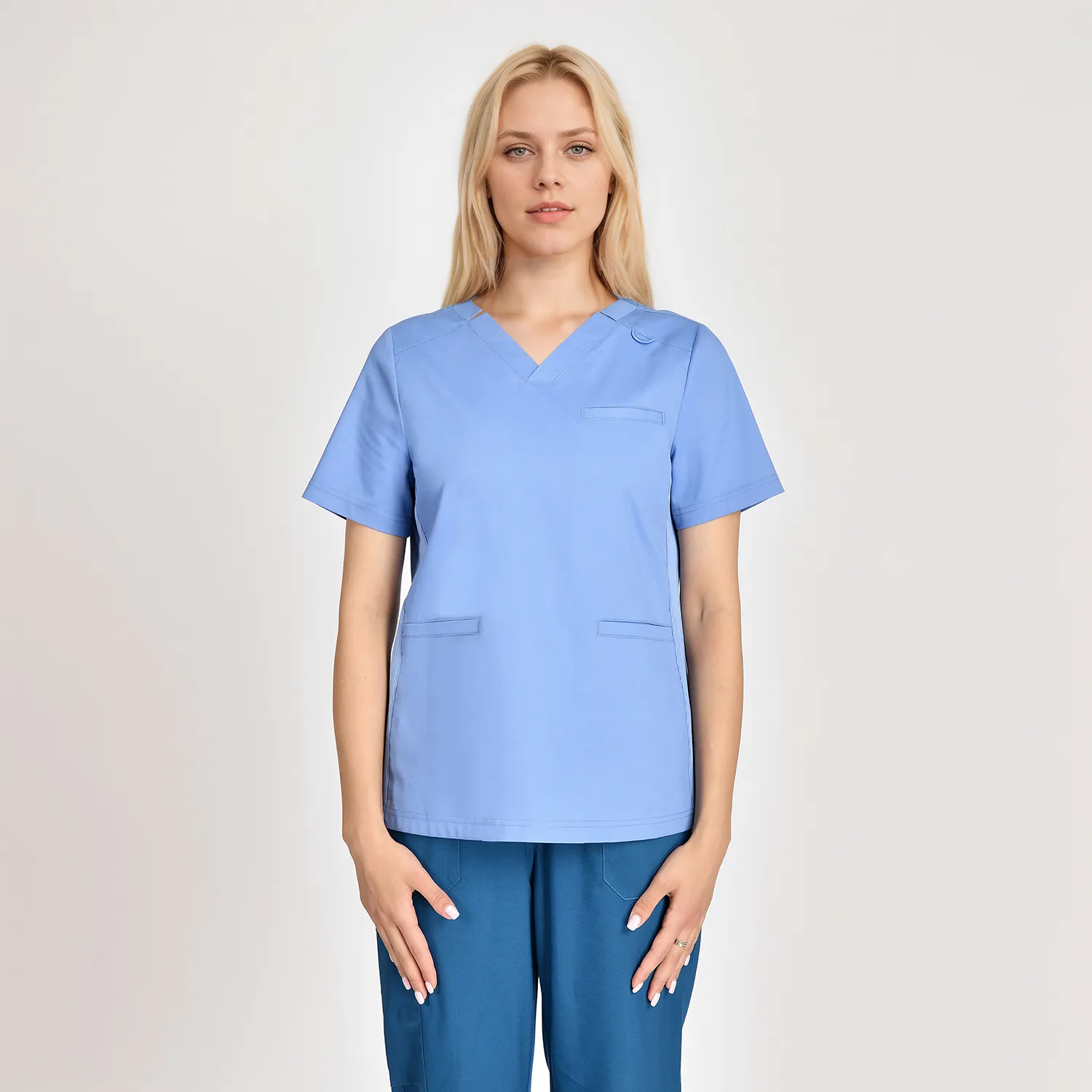 Women's blue V-neck scrub top with functional pockets, designed for comfort and ease in healthcare environments.