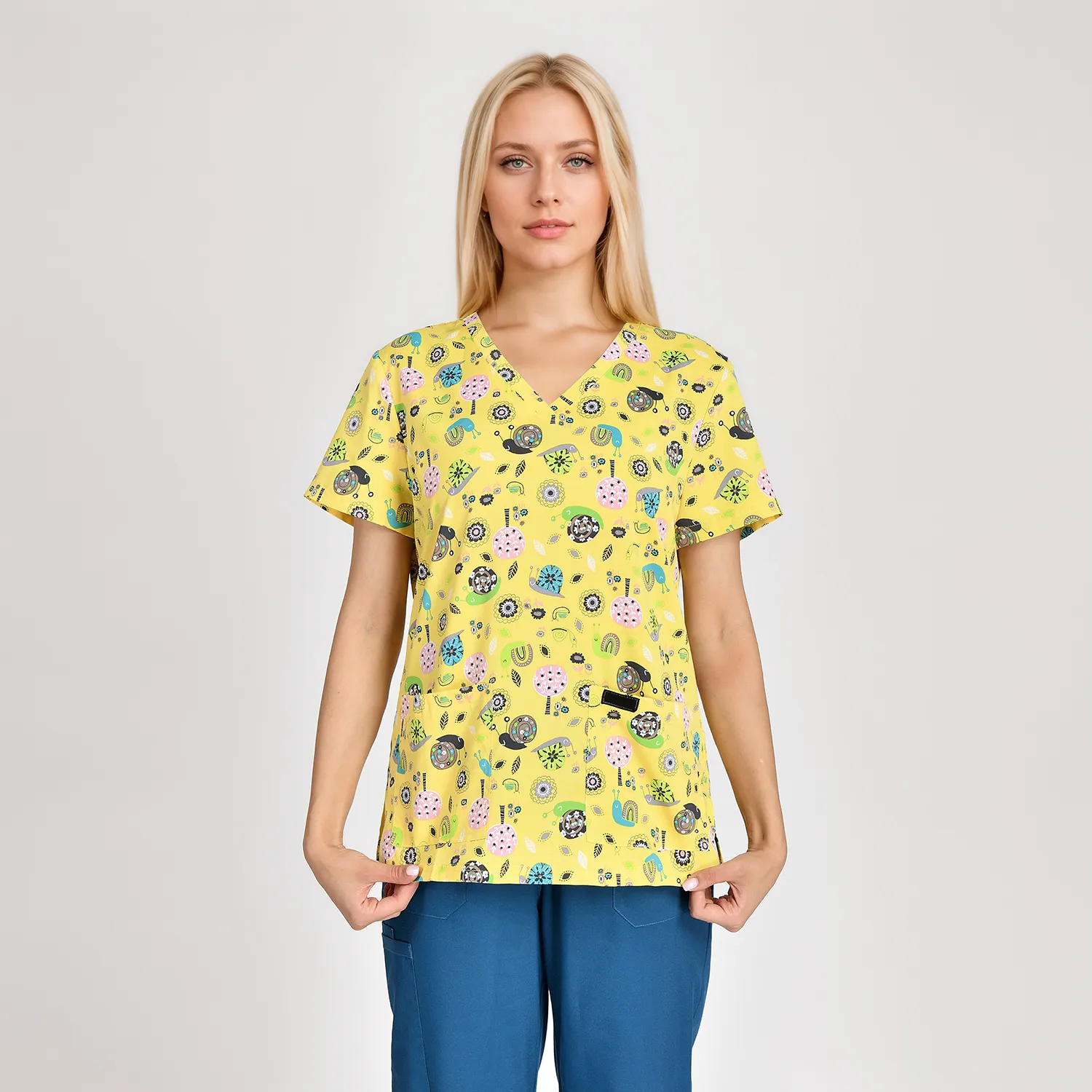 Women's yellow floral print medical scrub top with a v-neck, two side pockets, showcasing comfort and style.