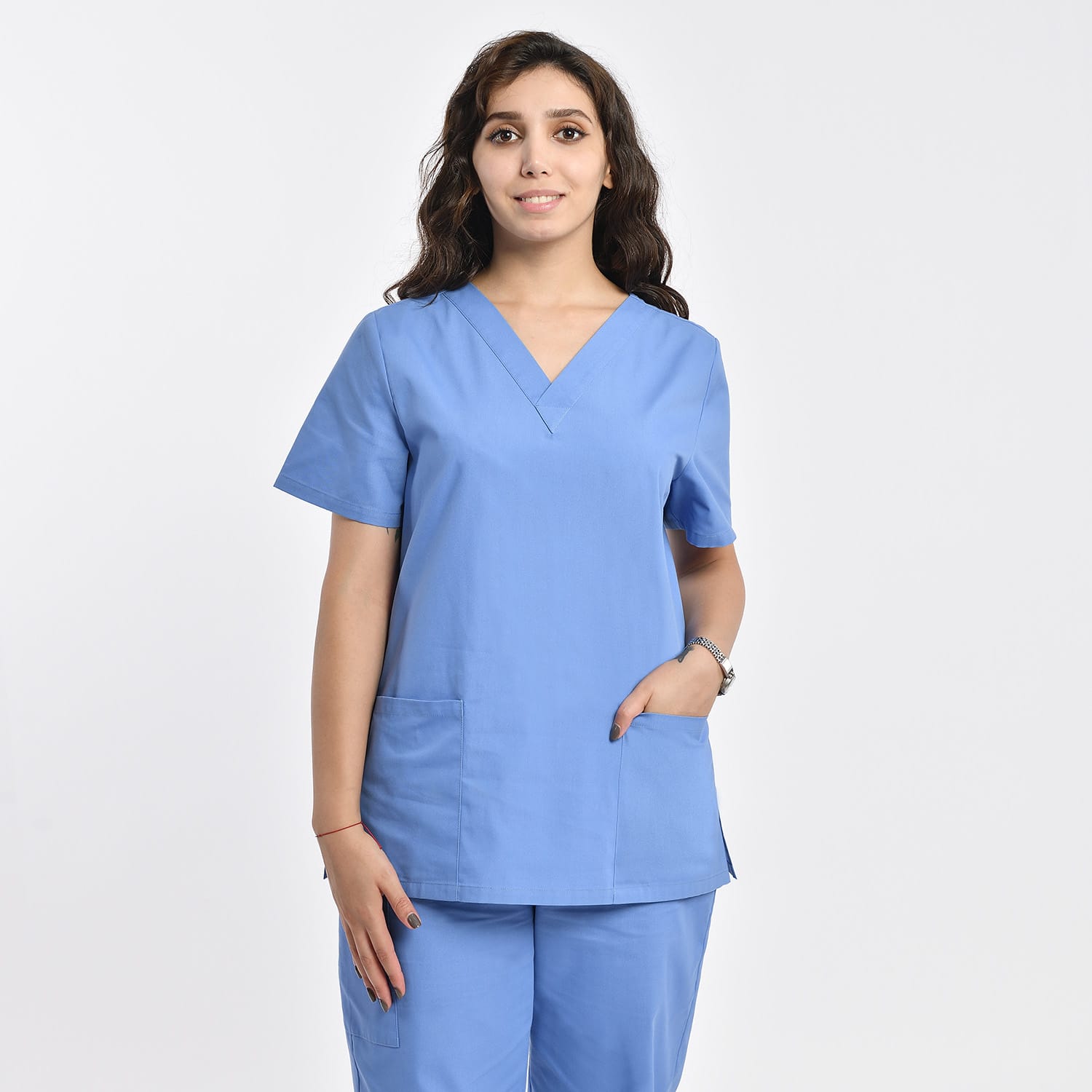 Front view of a model wearing a light blue women’s 2-pocket V-neck scrub top, ideal for healthcare workers.